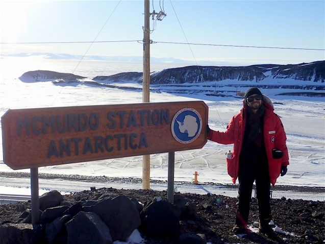 Julian Spergel posed with McMurdo Station Antarctica sign. Photo: Julian Spergel