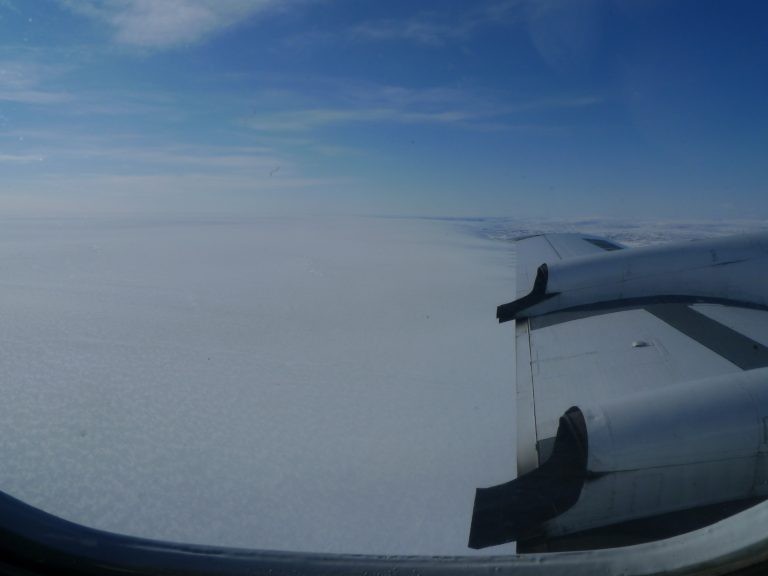 The largely featureless surface of the Greenland ice sheet, as seen from the window of a P3 aircraft carrying geophysical instruments aimed at detecting geologic features underneath.