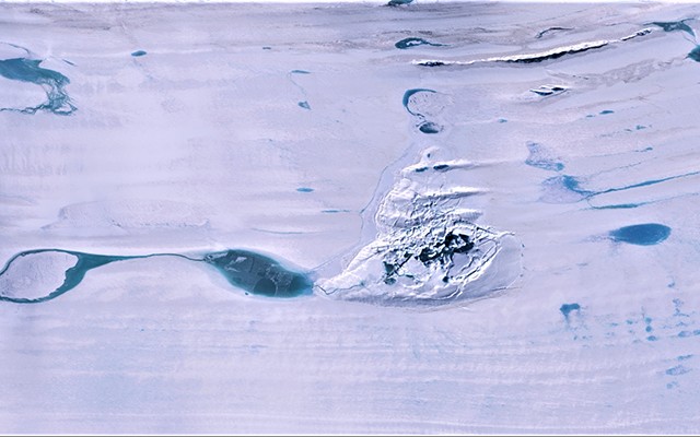 At center, the fractured ice of a doline on the Amery Ice Shelf, where a large subsurface lake drained through the bottom. Surface melt-water ponds surround the feature. (NASA ICESat-2 image)