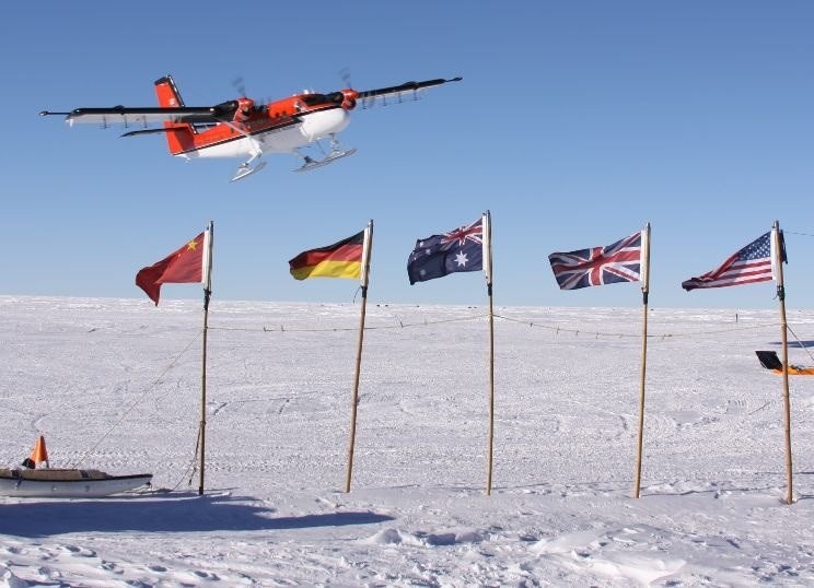 Survey aircraft takeoff with AGAP partner countries' flags in the foreground. Photo: Michael Studinger (LDEO)