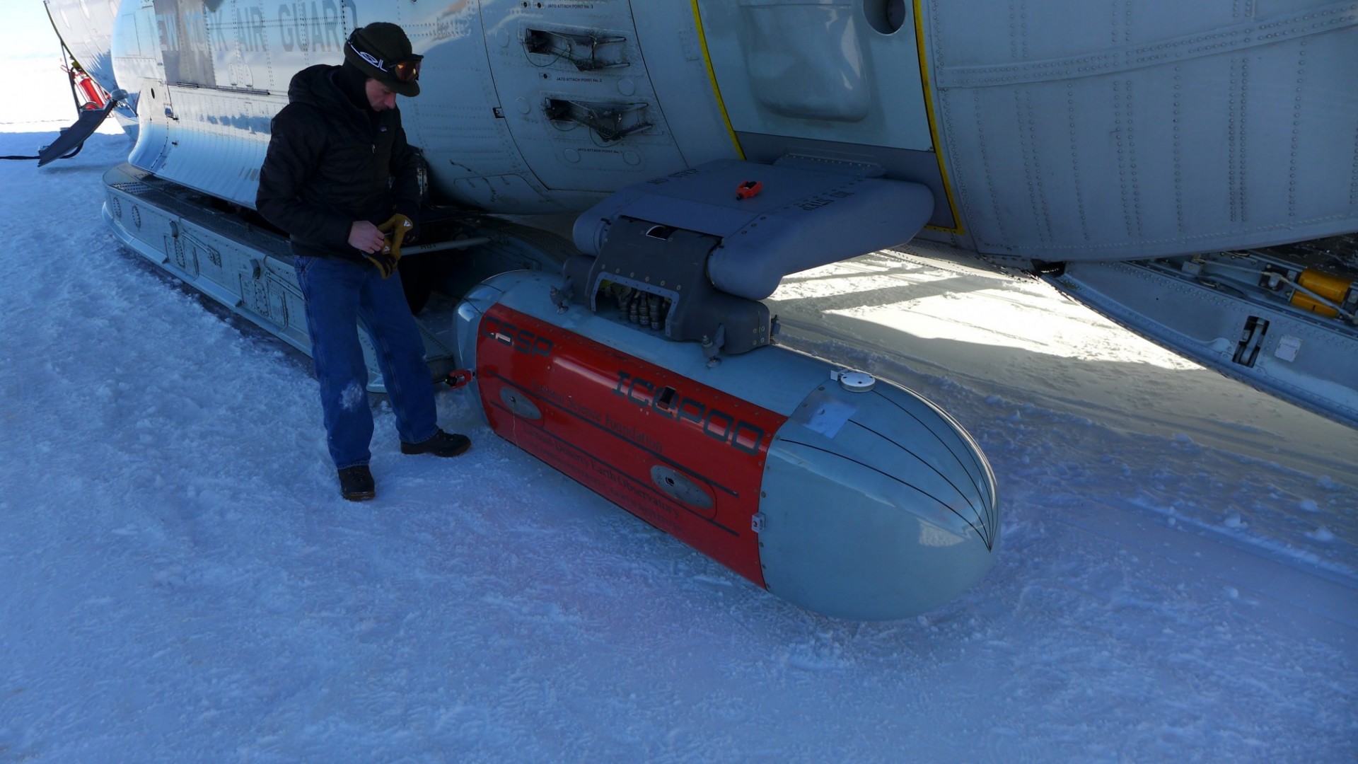 Engineer installs IcePod onto aircraft in Antarctica. Photo: Martin Wearing