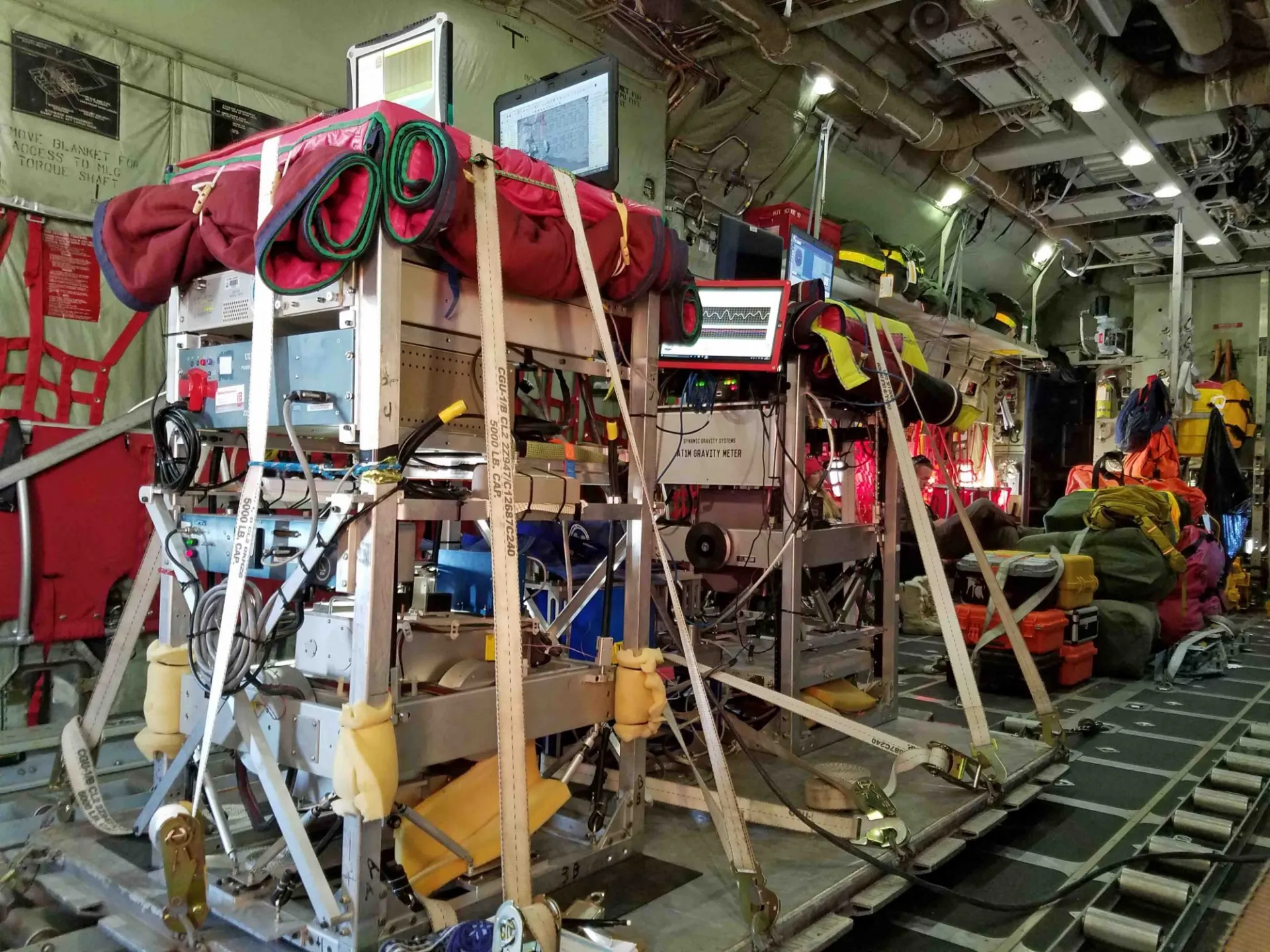 Gravity meters strapped to a cargo pallet inside the cargo hold of an aircraft. Photo: Beth Burton (USGS)